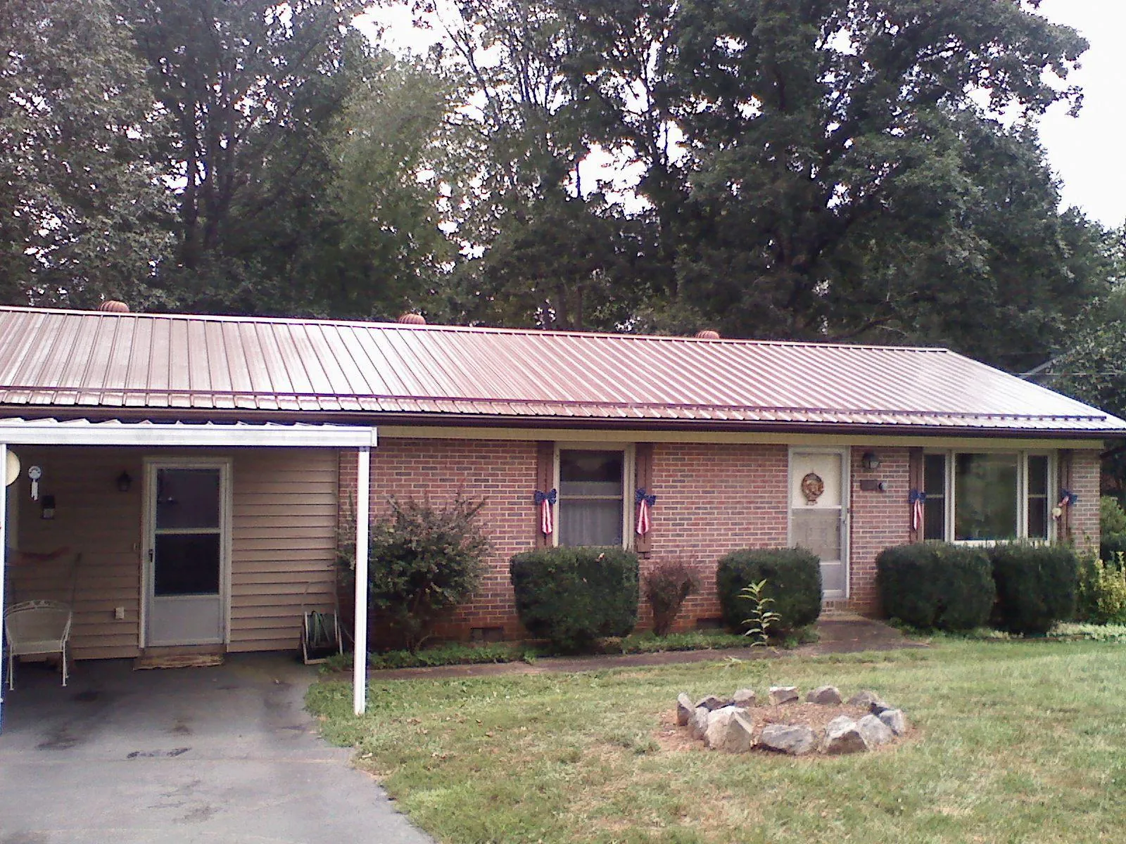 Bronze metal roof and carport on a brick ranch home — Roof Repair work by our crew in Erhard