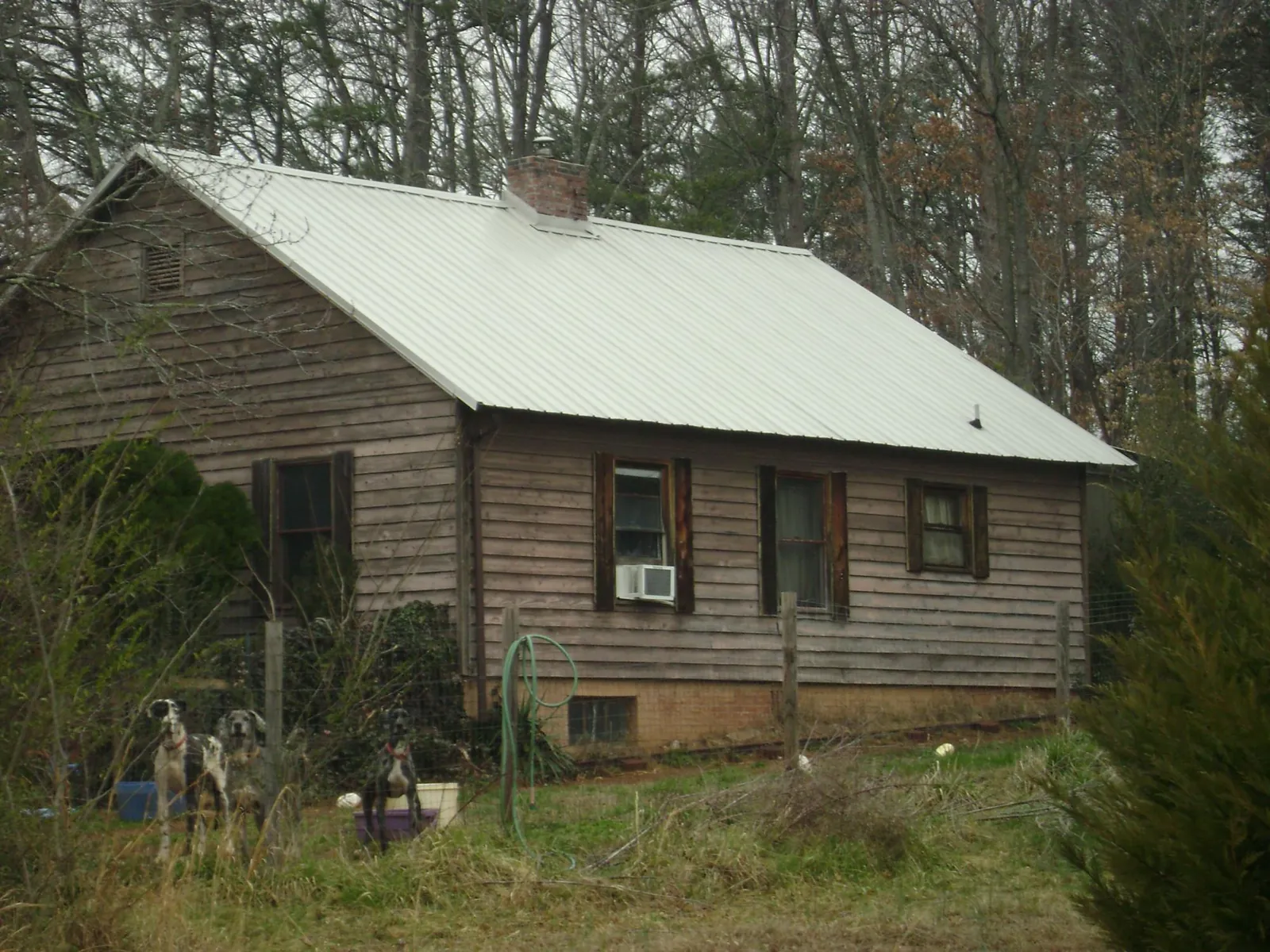 White metal roof on an old wood sided farmhouse, from a Metal Roof Installation job in Erhard